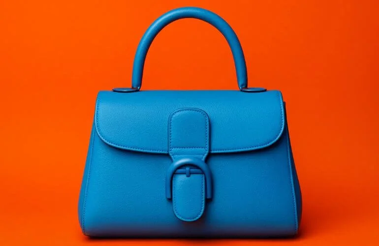 handbag product photo against vibrant orange background using complementary colors