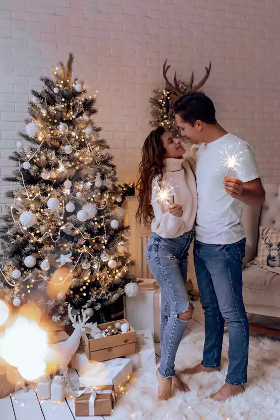 couple posing in front of a Christmas street